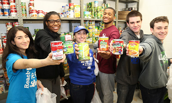 Group of students holding cans of food